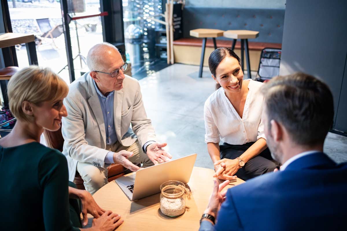 Business partners visiting over coffee at cafe